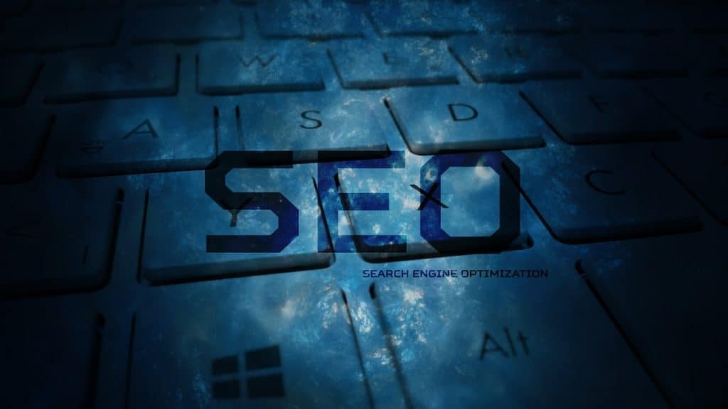 SEO written in the foreground of the image, with computer keyboard faded in the background